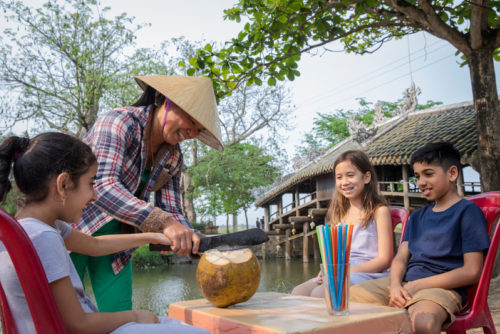 Local Woman Serving Coconuts Kids Sitting Credit Gadventures